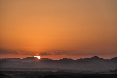 Güneş, Mısır 'da gün batımında çölden dağların arkasına saklanıyor.