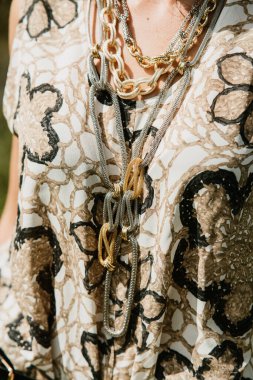 Altın zincirli ve deri çantalı kadın elleri