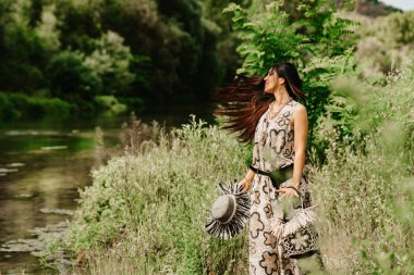 Ormanda çantalı genç bir kadın.