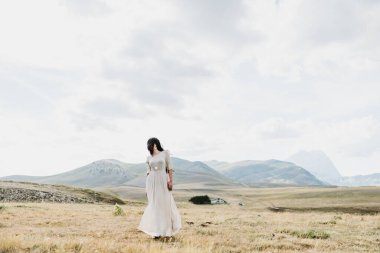 Dağlarda poz veren güzel genç bir kadın