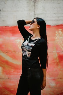 Duvarın önünde poz veren genç kız.