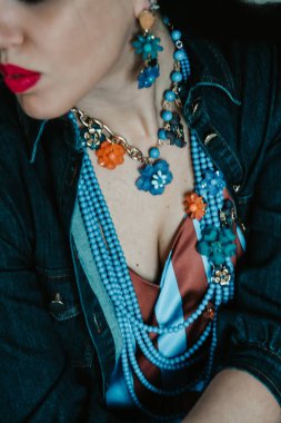 Kırmızı dudaklı, mavi boncuklu kadın.