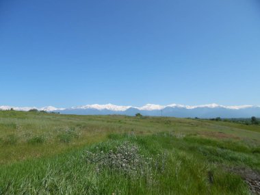 Dağları ve mavi gökyüzü olan güzel bir manzara.