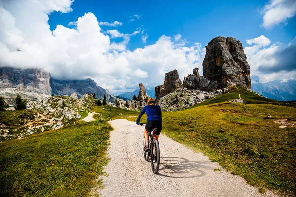 女性はイタリアのドロマイトで電動マウンテンバイクに乗っています 美しい山道でマウンテンバイクの冒険 — ストック写真