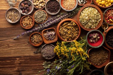 Doğal tıp geçmişi. Kırsal ahşap masadaki çeşitli kuru otlar, havan ve bitkiler..