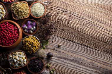 Doğal tıp geçmişi. Kırsal ahşap masadaki çeşitli kuru otlar, havan ve bitkiler..
