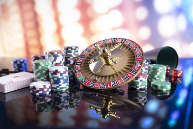Kumarhane teması. Kumar oyunları. Renkli bir arkaplanda rulet, zarlar, kartlar ve poker çipleri.