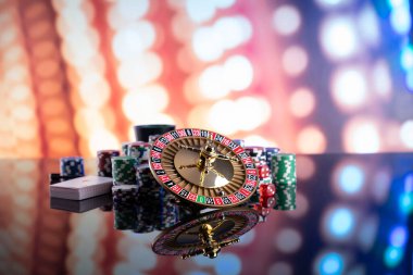 Kumarhane teması. Kumar oyunları. Renkli bir arkaplanda rulet, zarlar, kartlar ve poker çipleri.