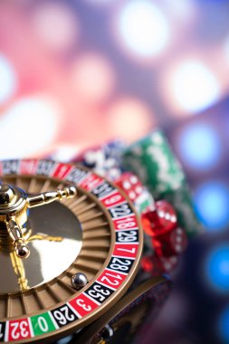 Kumarhane teması. Kumar oyunları. Renkli bir arkaplanda rulet, zarlar, kartlar ve poker çipleri.