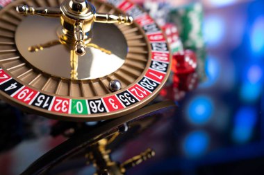 Kumarhane teması. Kumar oyunları. Renkli bir arkaplanda rulet, zarlar, kartlar ve poker çipleri.