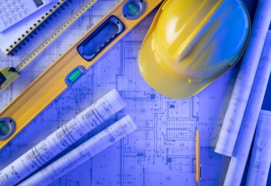 Müteahhit teması. Müteahhitin planları, defter ve alet çantası: sarı başlık, karalama, testere ve yarda..