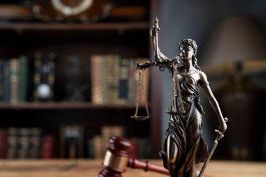 Avukatlık bürosu. Hakimler tokmak, heykel ve hukuk kitapları kitaplıkta..