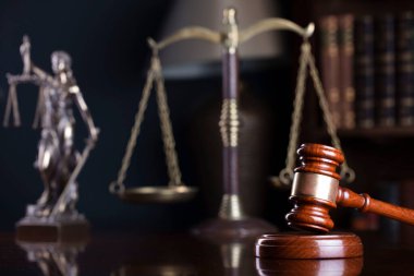 Avukatlık bürosu. Hakimler tokmak, heykel ve hukuk kitapları kitaplıkta..