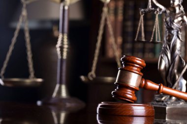 Avukatlık bürosu. Hakimler tokmak, heykel ve hukuk kitapları kitaplıkta..