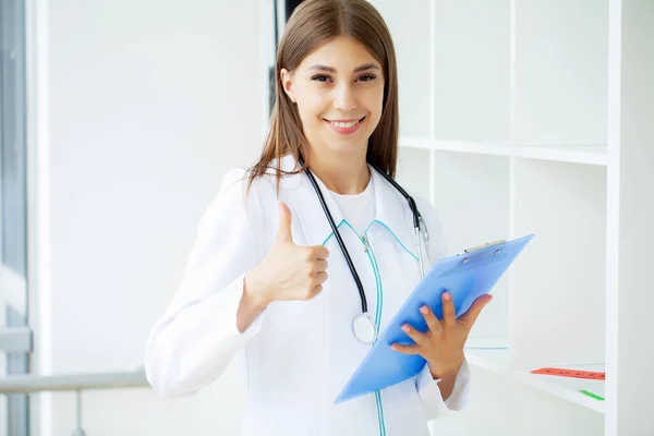 Female Doctor Surgery Reading Patient Notes — Stock Photo, Image