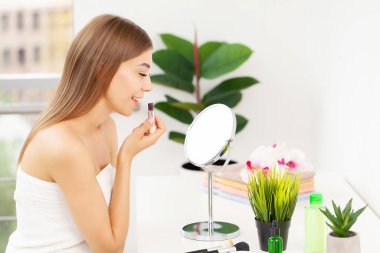 Sabah banyoda kirpik üzerine rimel kullanan bir kadın.