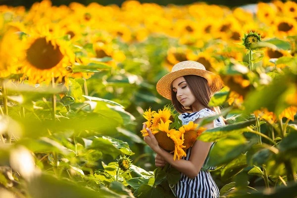 美丽的金发女子戴着草帽 黄昏时分在花田里 — 图库照片
