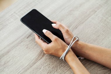 Erkek elleri zincirli ve akıllı telefonu tutuyor..