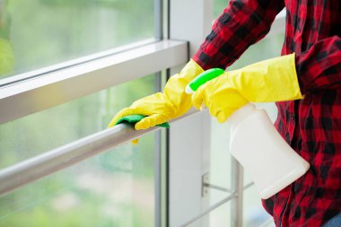 Genç bir kadın profesyonel temizlikçi modern bir ofisi temizliyor..