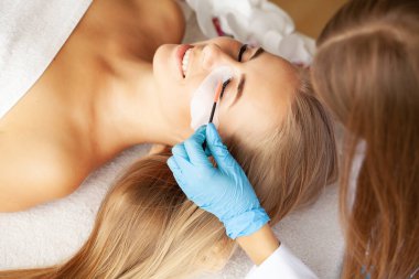 Salonda kirpik kaplaması olan genç bir kadın..