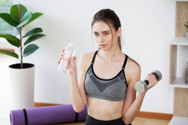 Fitness egzersizleri evde yaptıktan sonra güzel ve genç birbayan içme suyu.