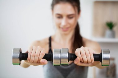 Sportif genç bayan oturma odasında tek başına sabahları egzersiz yapıyor..