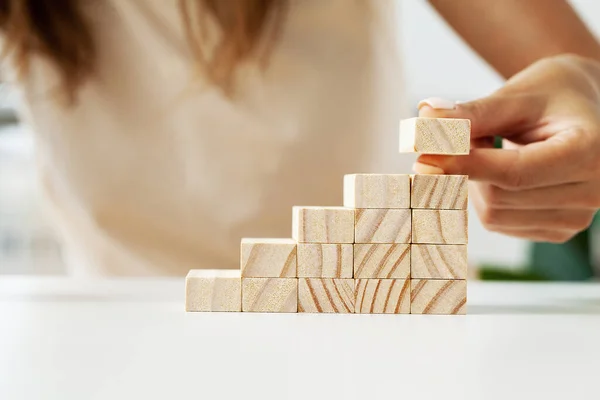 stock image Woman hand putting and stacking blank wooden cubes on desk.