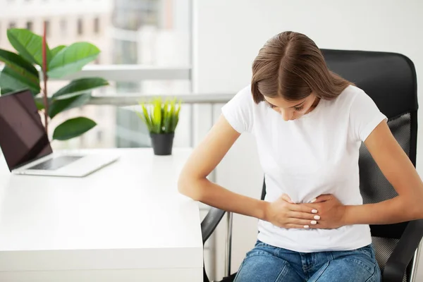 Stock image Business woman feeling painful from stomach ache illness during working at office.