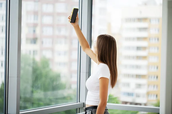 stock image Young woman holding smartphone, typing message, chatting with friends in social networks