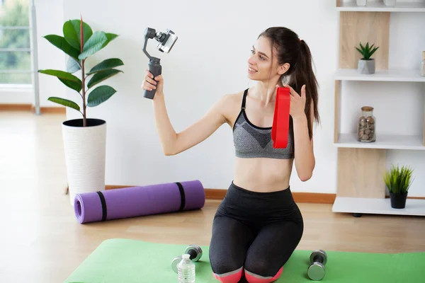 stock image Sporty young woman recording video online yoga lessons in comfort of her own home.