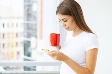 Tembel kadın ofiste rahatla. Akıllı telefon uygulamaları kullan..