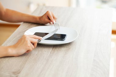 Akıllı telefon ekranına bakan çekici bir kadın, medya haberleri okuyor..