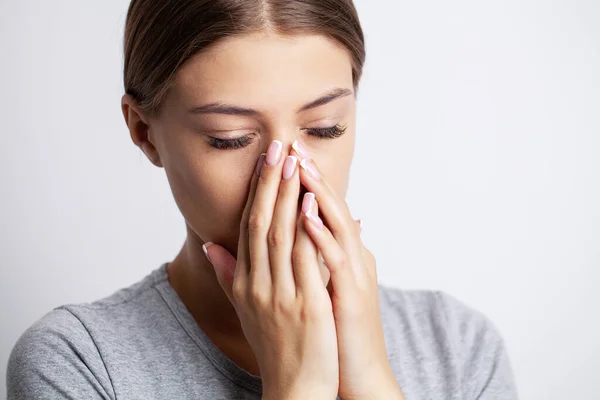 A young woman is sick and has a runny nose.