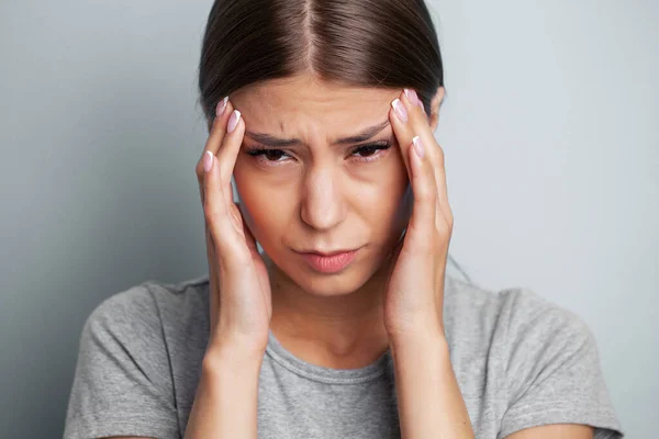 若い疲れている女性は頭痛を感じ 手で痛みの場所を保持します — ストック写真