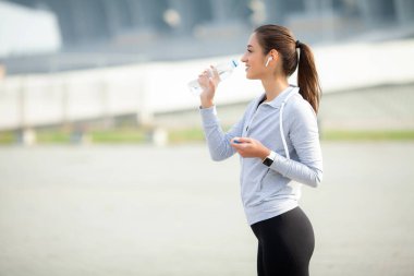 Elinde su şişesi olan fit bir genç bayan portresi.