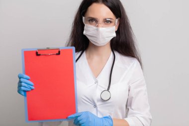 Metin için boş bir sayfa tutan kadın doktor..