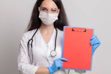 Metin için boş bir sayfa tutan kadın doktor..