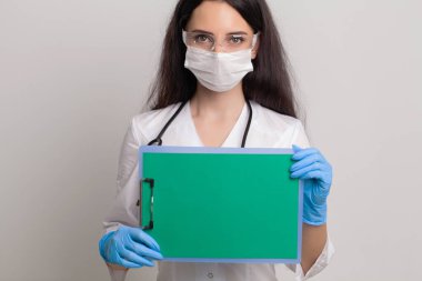 Metin için boş bir sayfa tutan kadın doktor..