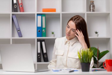 İşkadını bilgisayarla çalışıyor konsantre ve gülümsüyor..