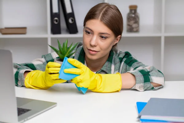 黄色の手袋で作業机を拭く女性の手 — ストック写真