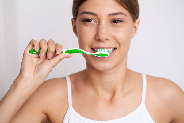 портрет красивой молодой женщины, чистящей зубы.