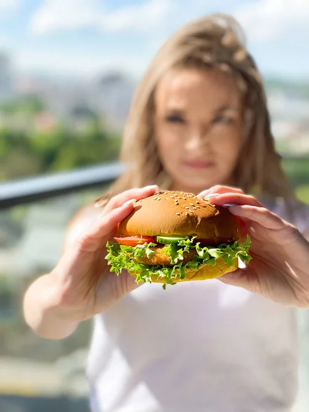 Young woman eating hamburger woman eating junk food.