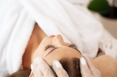 Güzellik salonunda masaj yaptıran bir kadın..