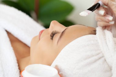 Güzel Afrikalı kadın güzellik merkezinde yüz masajı yaptırıyor..