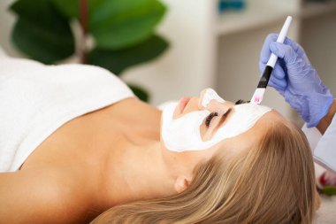 Güzel Afrikalı kadın güzellik merkezinde yüz masajı yaptırıyor..