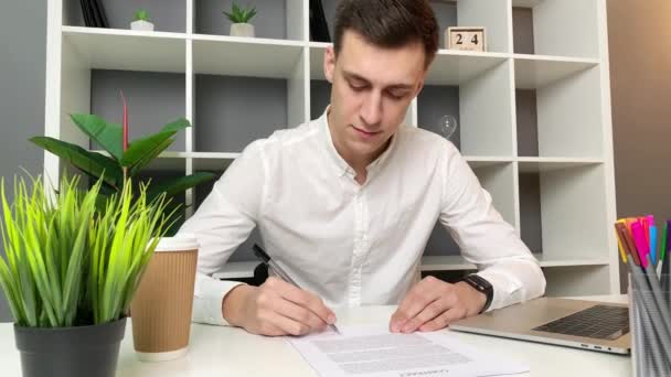 Молодий Чоловік Читає Підписує Контракт Офісі — стокове відео