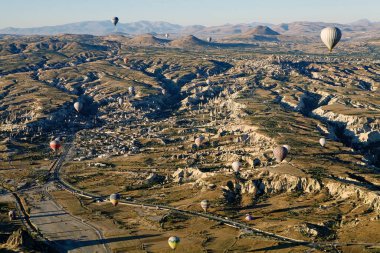 Cappadocia hot air baloon trip, Turkey. Tourists on board Hot air baloons are landing in Cappadocia
