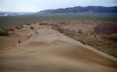 Kazakistan 'daki Altyn Emel Ulusal Parkı' ndaki Aktau Dağları 'ndaki şarkı söyleyen kum tepesi. 1996 'da yaratıldı. Park, Lli Nehri ve Aktau dağ sırası arasında yaklaşık 4600 kmq lik bir alana yayılmış ve çoğunlukla çöl ve kayalık araziye ev sahipliği yapmaktadır.