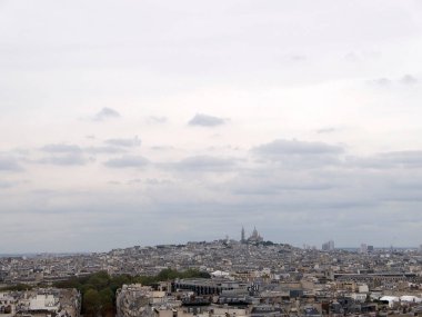 Paris 'teki Arc de Triomphe şehrinin arka planında Montmartre var. Arch de Triomphe, Paris 'in en ünlü anıtlarından biridir.