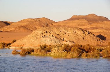 Mısır 'daki Nasser Gölü kıyısındaki dağların ve çöllerin arasında mezarlar. Nasser Gölü, Aswan Barajı 'nın soyutlanmasıyla kuruldu.
